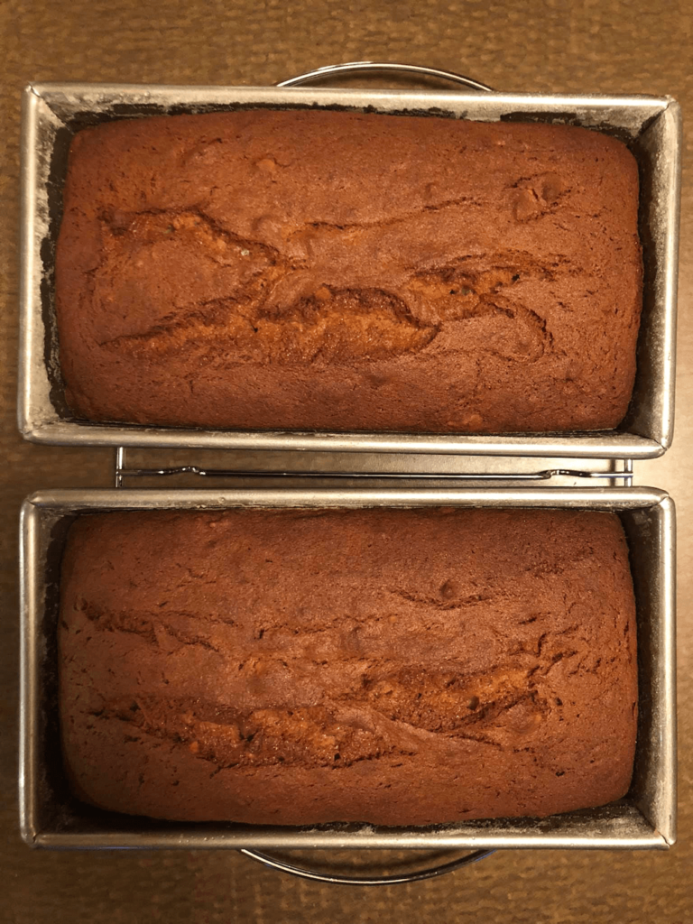2 loaves of homemade banana bread in silver metal loaf pans - less expensive to bake your own compared to buying in a store